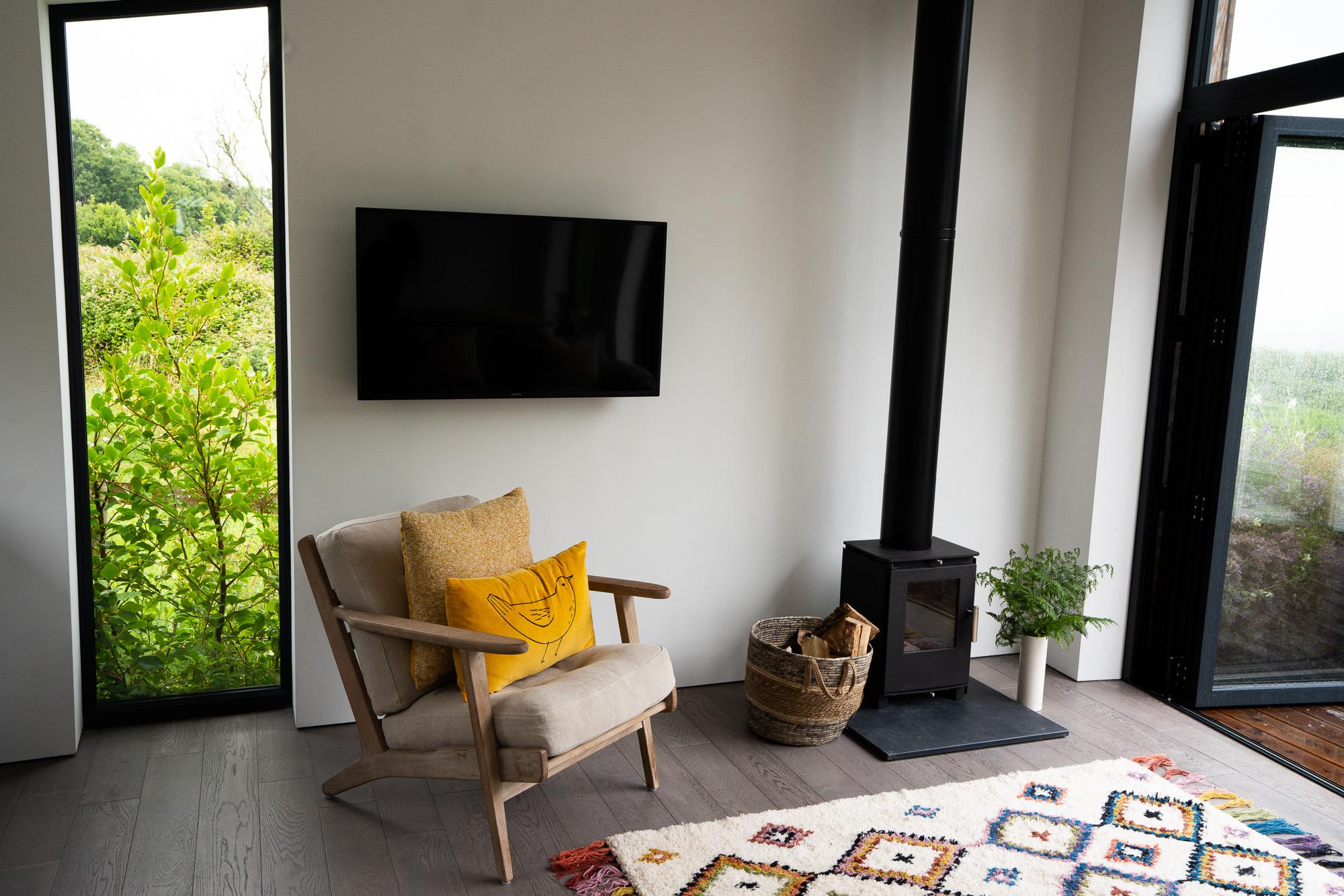Lounge seating and log burner stove with mounted TV