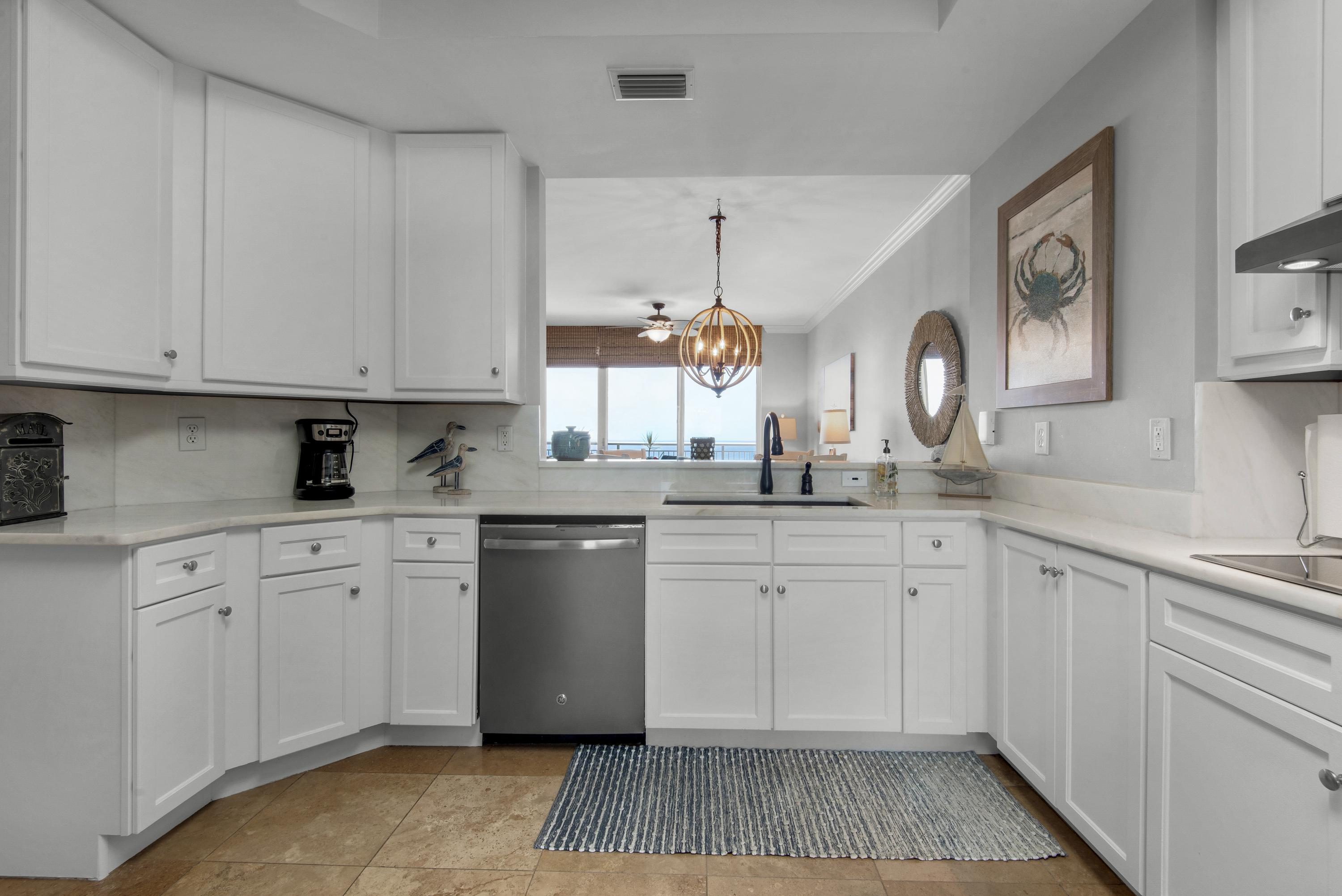 Kitchen with full view through to the living area, dining table and Gulf waters