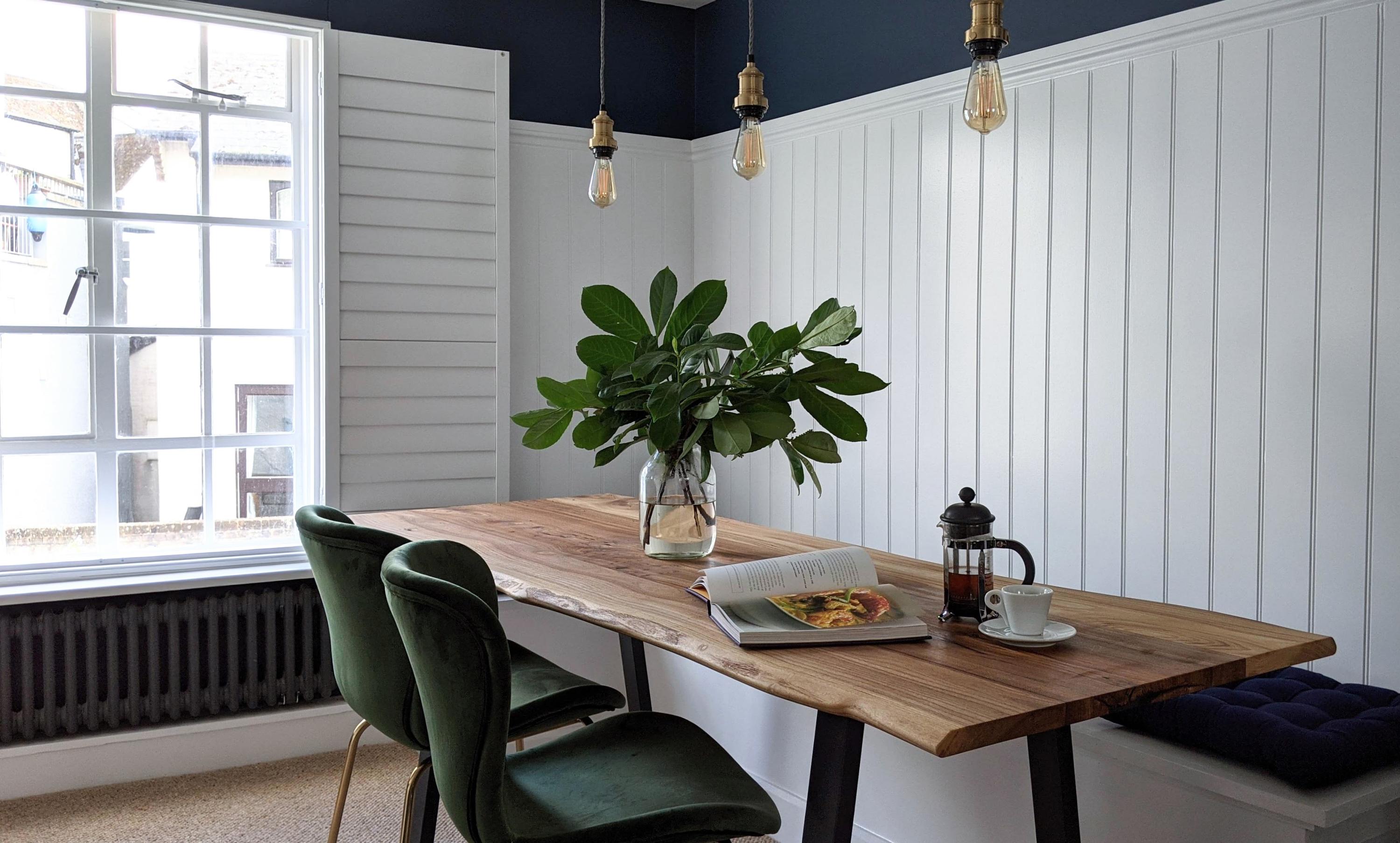 Hand crafted bench seating and bespoke cut and crafted wooden elm dining table with velvet chairs and over hanging lights this boutique and style centric design of this  dining space with river views flows throughout  the first floor of this deluxe holiday property  in Lyme Regis