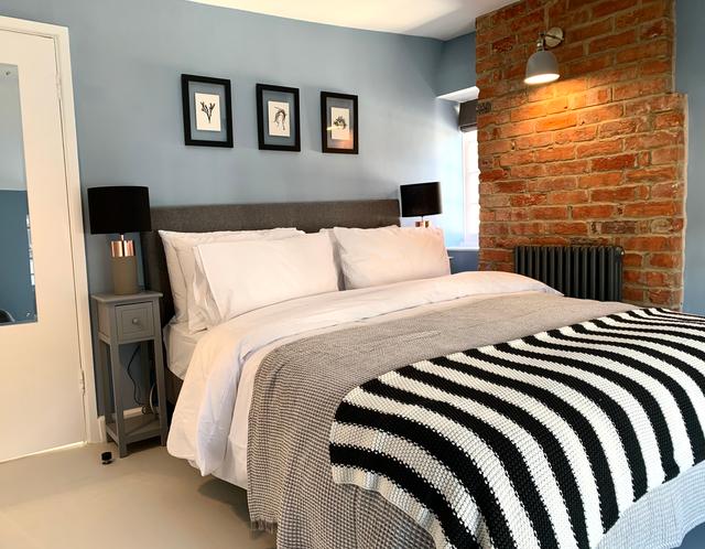 Boutique getaway bedroom with king size bed period features with stone work and luxury bedding and linen