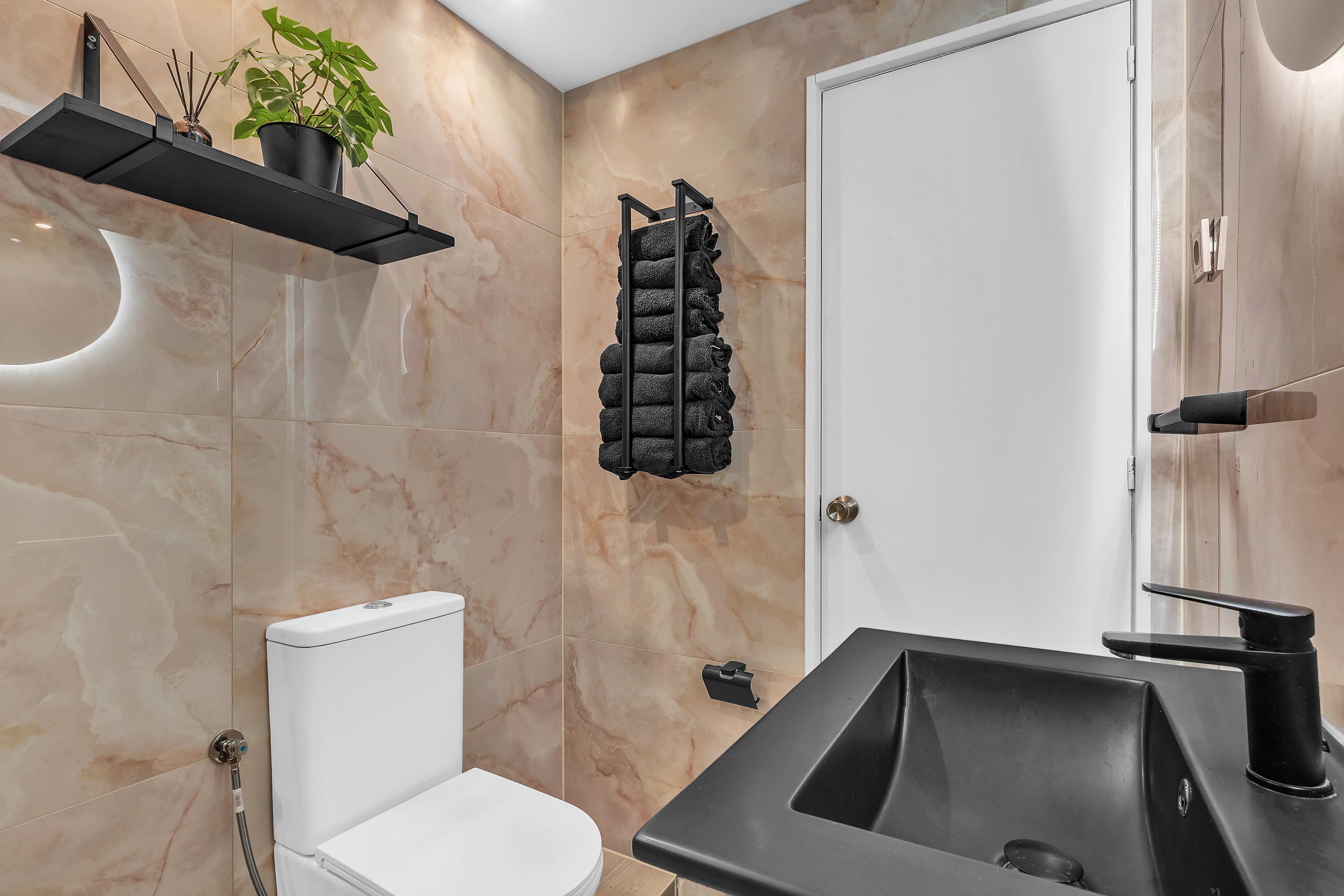 Moderne badkamer met regendouche, toilet en wastafel in Casa Xanti II