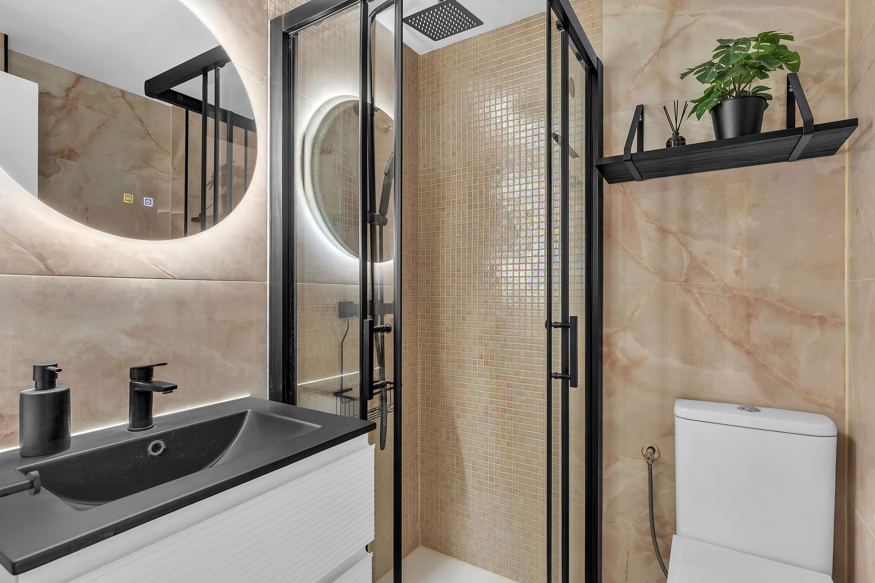 Badkamers met spiegelverlichting en luxe afwerking in Casa Xanti II, La Carihuela