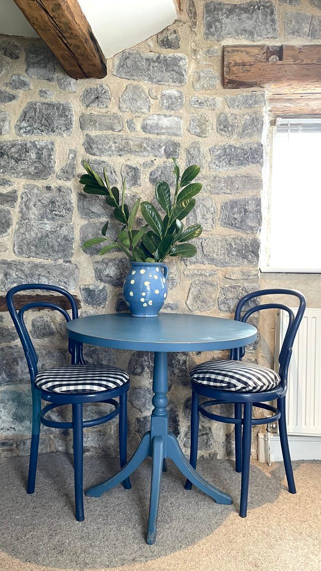 A distinguished table for two in the lounge for sitting and dining, stone walls and river window views, a cosy happy holiday cottage