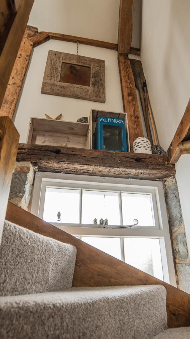 Period beam work, sash windows and characterful winding staircase with sunshine pouring through showing all the period features stonework and displays of local fossils 