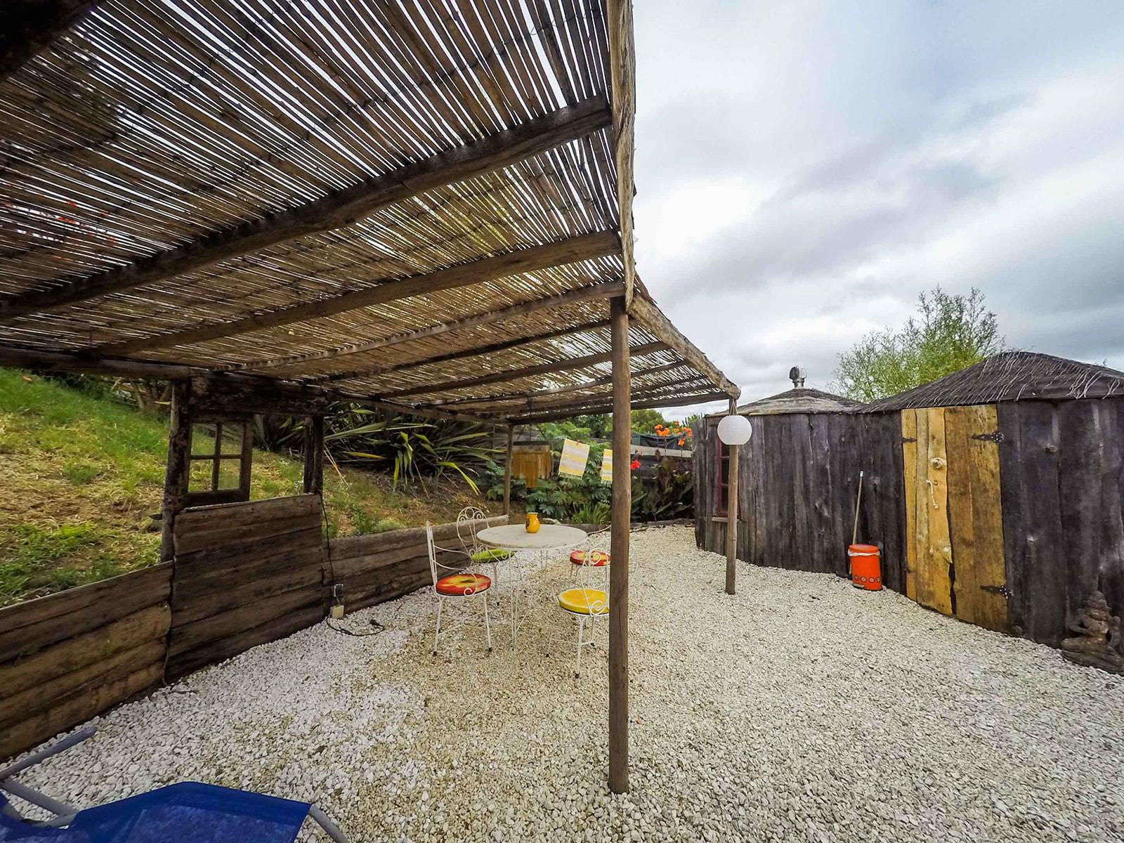 Shaded lounge area outside yurt with gravel floor