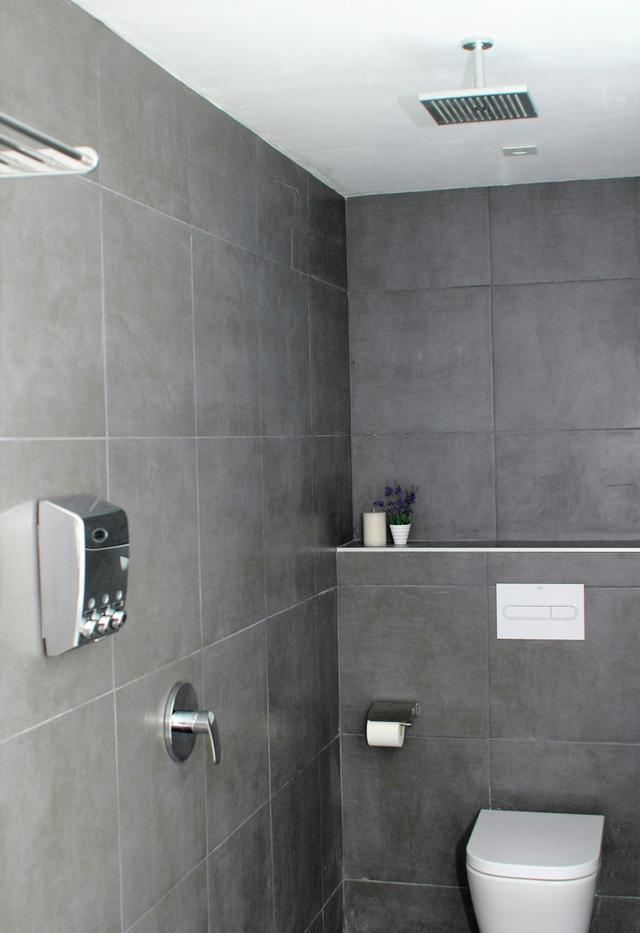 Private bathroom with modern finishes and wash area with natural details and a calm, refined look.
