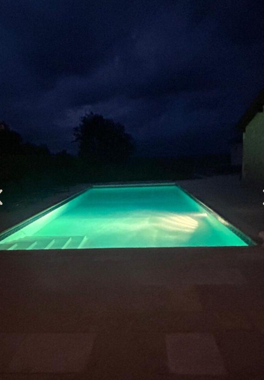 Het verwarmde privézwembad verlicht in de avond