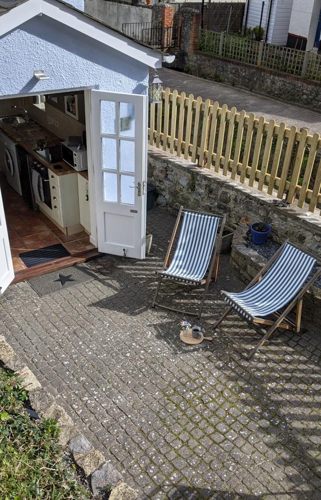 Courtyard with deck chairs opening into the kitchen via french doors and over looking the River Lym with river views