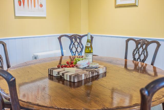 Large oak round table in the holiday home kitchen and dining room. Period and contemporary stylish holiday interiors