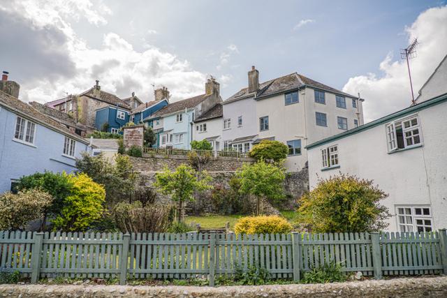 Large garden with green wooden fencing and river Lym running past the holiday home and garden. Nestled in-between other period characterful cottages in Lyme Regis, by the river  and two minutes walk from the sea 