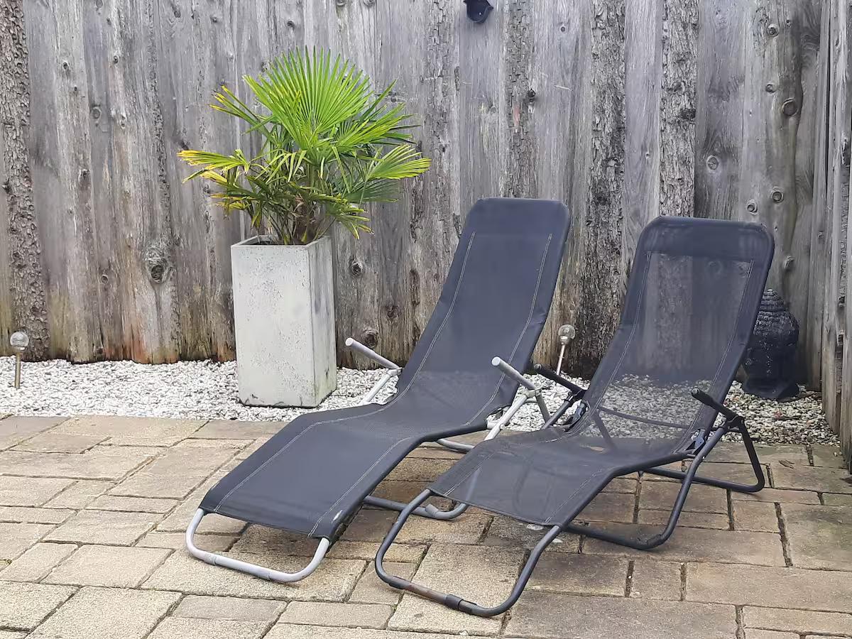Ligstoelen in de omheinde tuin