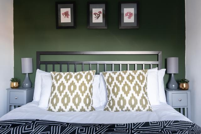 King size bed with local seaweed art pictures metal frame bed and contemporary stylish interiors in thsi two bedroom cottage in central Lyme Regis