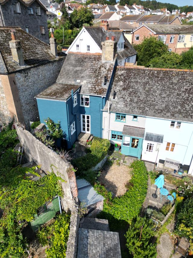 This Ariel view shows Seahorse Cottage exterior painted blue nestled in amongst other period cottages in central Lyme Regis courtyard walled garden 
