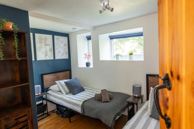 Twin bedroom with double windows to gardens at Lym River Cotttage apartment