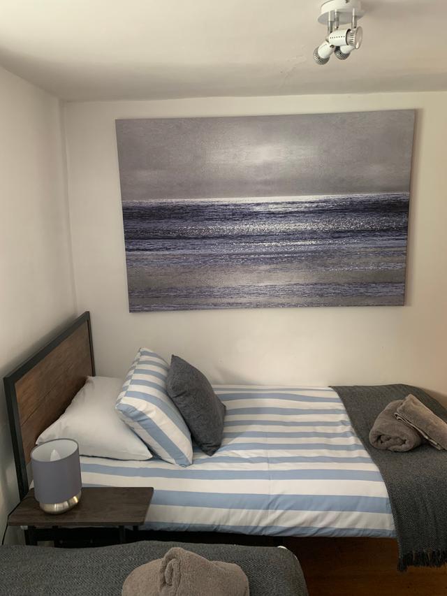 Twin bedroom with sea scape picture at Lym River Cottage Apartment