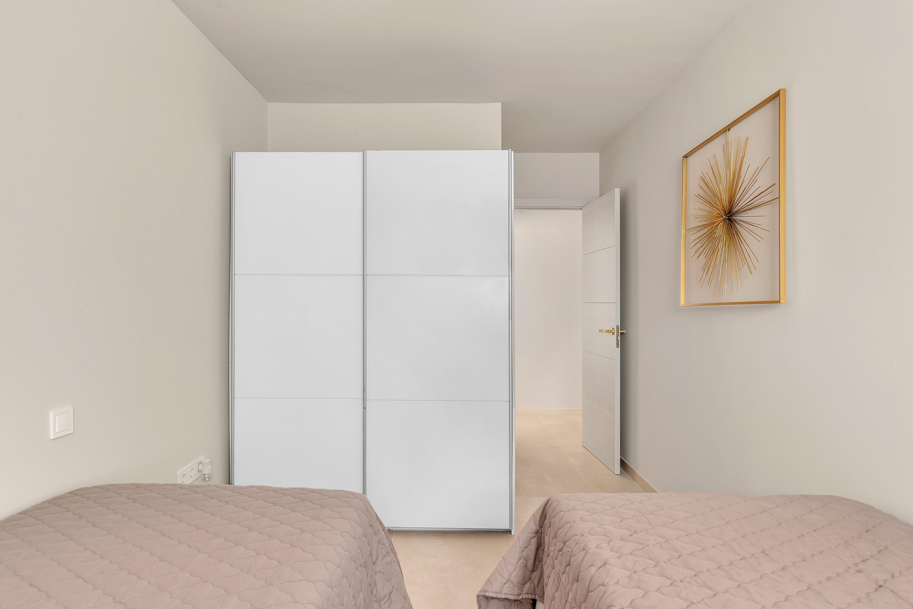Tweede slaapkamer met twee aparte bedden, airconditioning en opbergruimte – perfect voor families of vrienden.