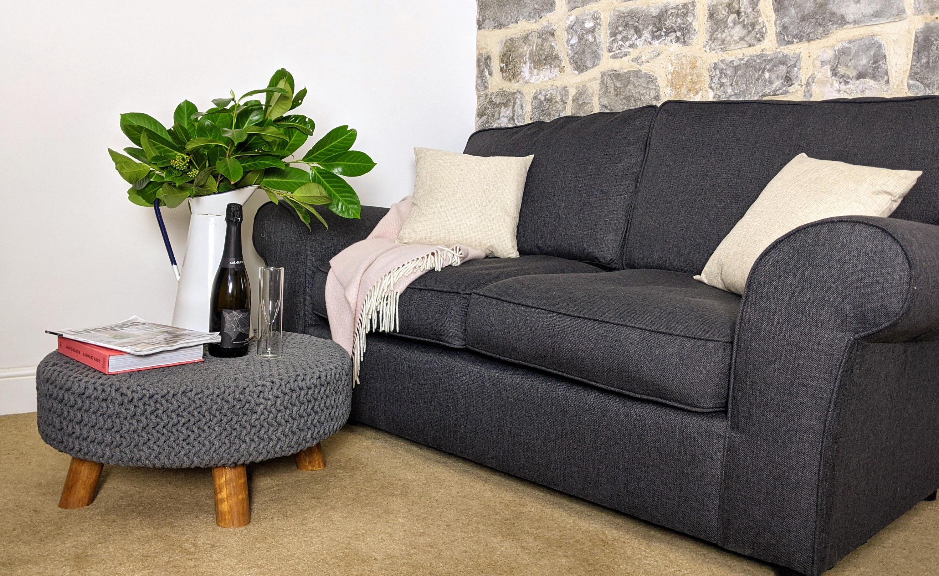 Comfy sofa and footstool in the living room of Lym Leat Holiday home in Lyme Regis