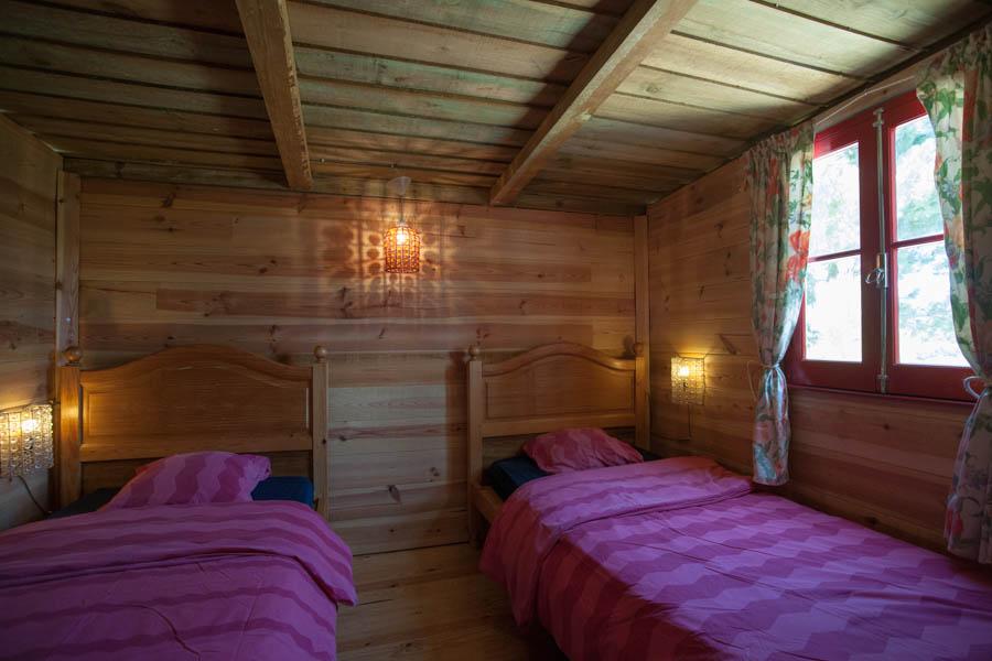 Rondavel bedroom with atmospheric lights, window and made beds