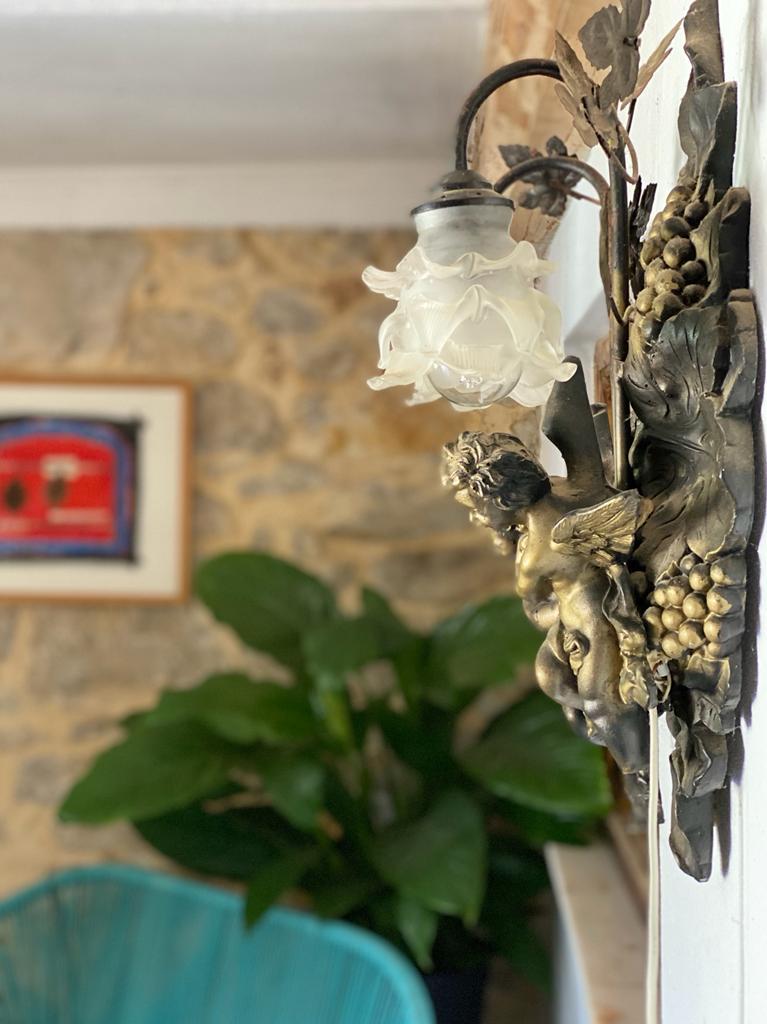 wall lamp decoration with plants and art in the background 