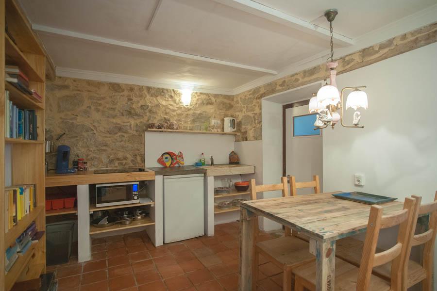 kitchen area inside of the loja with kitchen table, fridge, and atmospheric light