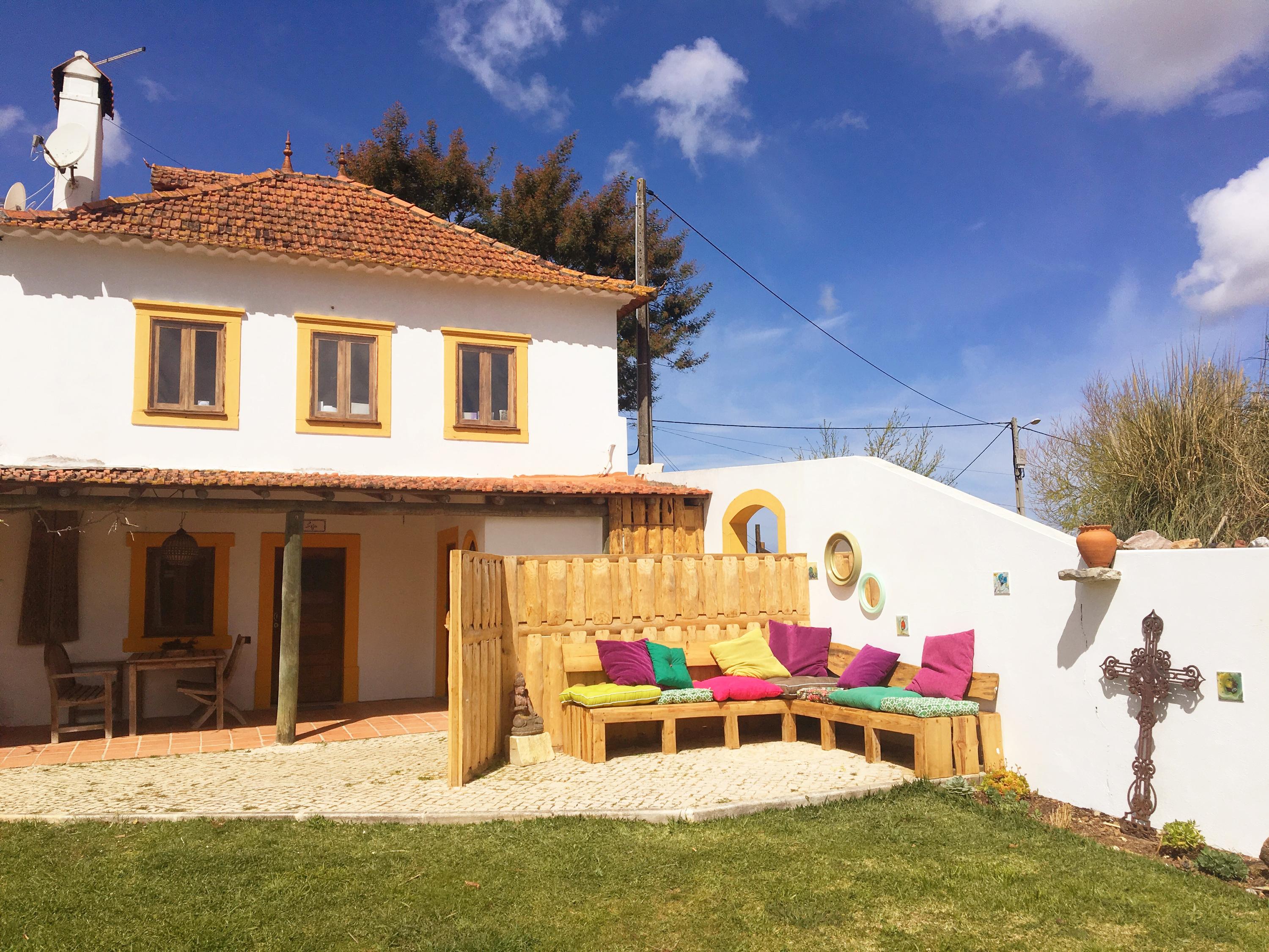 outdoor lounge area with colorful pillows and decorative wall art
