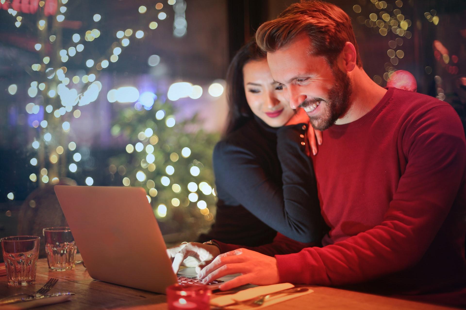 Couple happily looking at their laptop